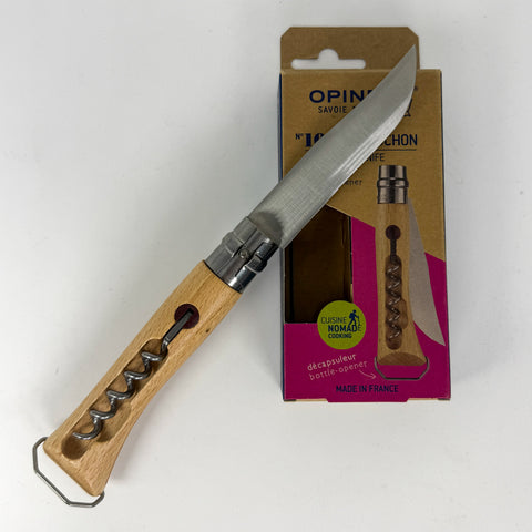 A wooden-handled corkscrew knife with a satin-finished steel blade, shown next to its brown cardboard retail packaging on a plain white background.