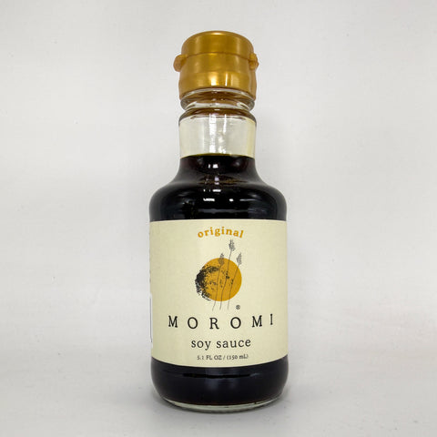 A bottle of Moromi soy sauce with a cream-colored label and a gold cap, set against a plain light gray background.