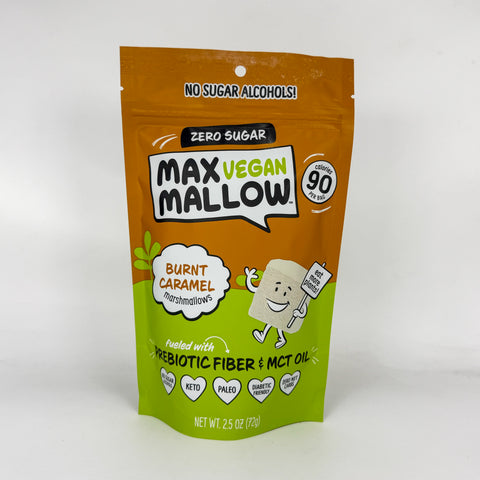 A stand-up pouch of Max Vegan Mallow prebiotic fiber and MCT oil in the Burnt Caramel Marshmallow flavor. The packaging features a bright orange top half and a lime green bottom half, with cartoon graphics of a marshmallow character and text indicating it is zero sugar and vegan.