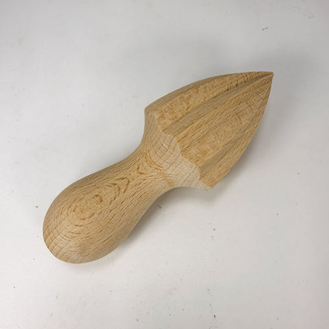 A handcrafted wooden citrus juicer with a natural light wood finish, displayed diagonally on a plain off-white background.