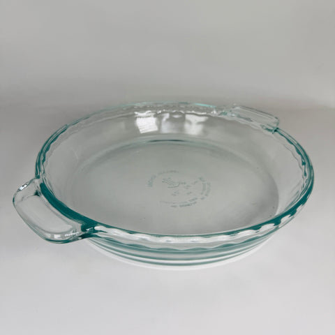 Glass pie pan on white background